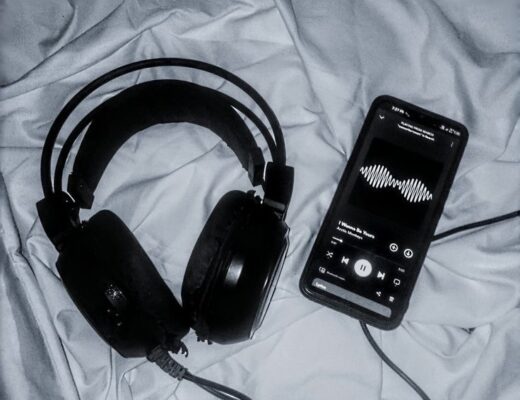 Cuffie e telefono sul letto che riproducono musica, ispirazione da una frase di una canzone sulla crescita personale